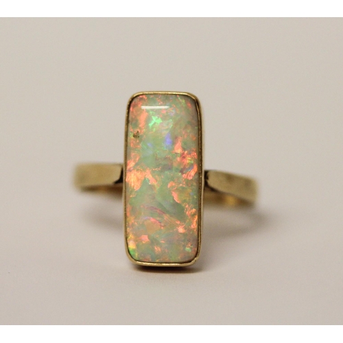 578 - A large opal dress ring, set with a rectangular doublet in rub over 14k gold setting and band, ring ... 