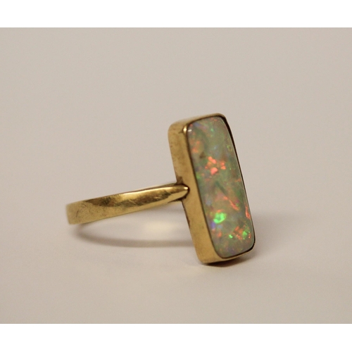 578 - A large opal dress ring, set with a rectangular doublet in rub over 14k gold setting and band, ring ... 