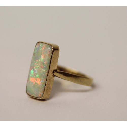 578 - A large opal dress ring, set with a rectangular doublet in rub over 14k gold setting and band, ring ... 