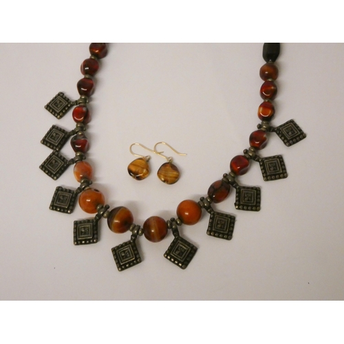 618 - An old Berber cornelian and white metal fringe necklace and a pair of banded agate drop earrings on ... 