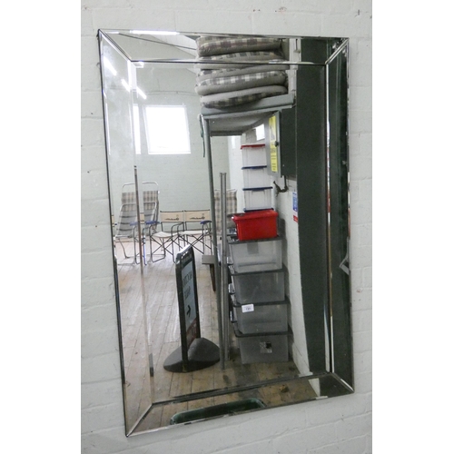 135 - A large bevelled frameless wall mirror