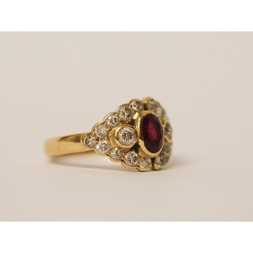 524 - A ruby and diamond cluster panel ring, set with an oval ruby surrounded by brilliant cut diamonds, 1... 