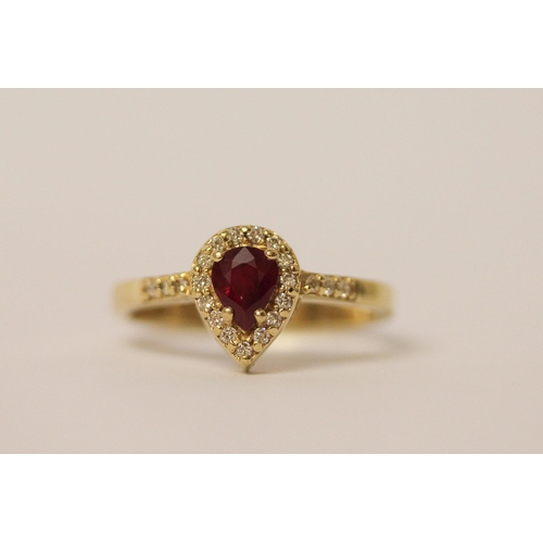 525 - A pear shaped ruby and diamond cluster ring, with diamond set shoulders on 14ct yellow gold band, ri... 