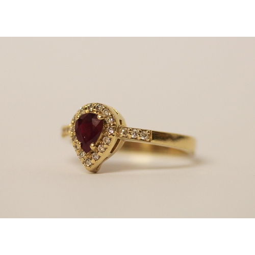 525 - A pear shaped ruby and diamond cluster ring, with diamond set shoulders on 14ct yellow gold band, ri... 