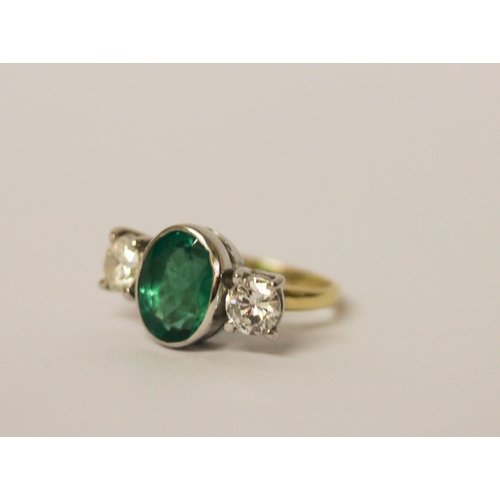 537 - An emerald and diamond three stone ring, the rub over set oval emerald estimated to weigh 2.4 carats... 