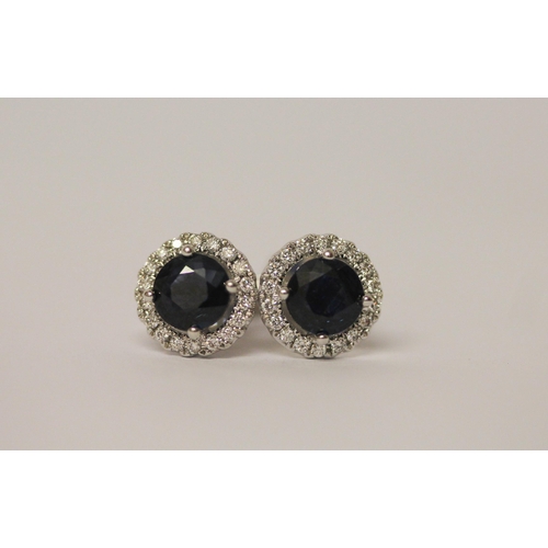 546 - A pair of modern 18ct white gold sapphire and diamond circular ear studs.