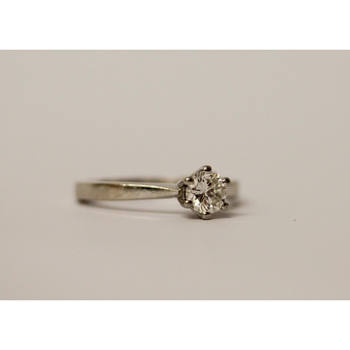 557 - A diamond engagement ring, with a brilliant cut diamond in claw setting, on hallmarked platinum band... 