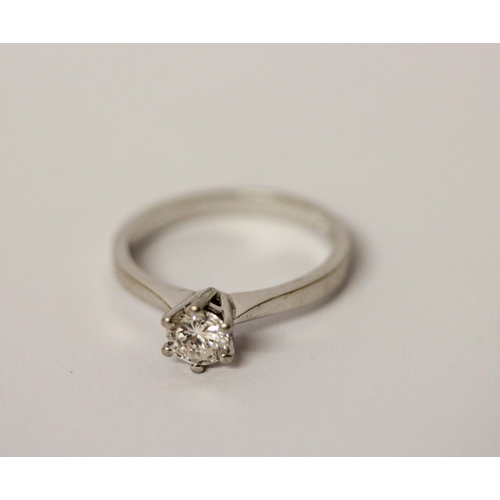 557 - A diamond engagement ring, with a brilliant cut diamond in claw setting, on hallmarked platinum band... 