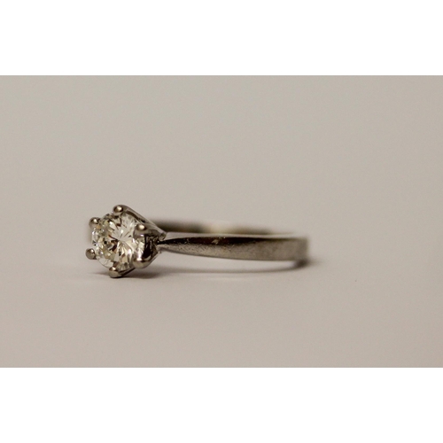 557 - A diamond engagement ring, with a brilliant cut diamond in claw setting, on hallmarked platinum band... 