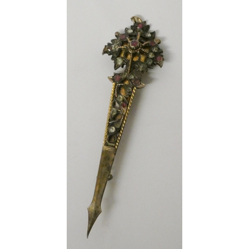 646 - A silver gilt turban pin with rubies and old rose cut white stones. 11 cms long