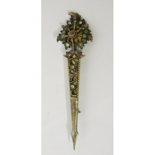 646 - A silver gilt turban pin with rubies and old rose cut white stones. 11 cms long