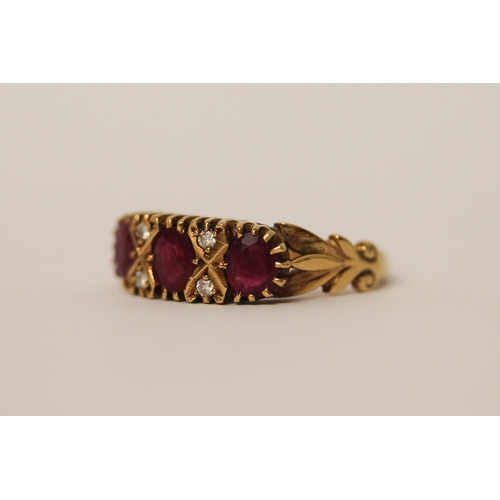 742 - A three stone ruby ring, in a Victorian style setting with small diamonds, hallmarked 18ct yellow go... 