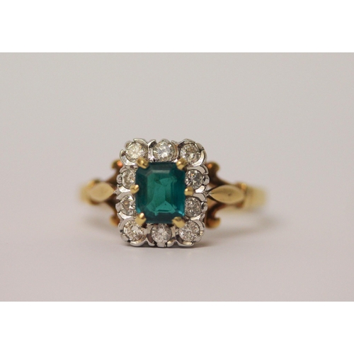 744 - An 18ct gold cluster ring, with emerald cut  green stone to the centre surrounded by diamonds, hallm... 