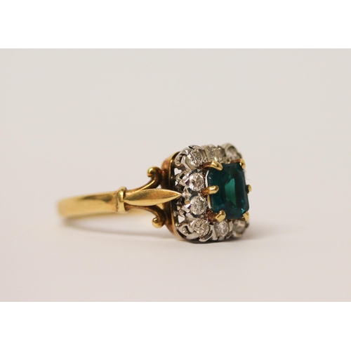 744 - An 18ct gold cluster ring, with emerald cut  green stone to the centre surrounded by diamonds, hallm... 