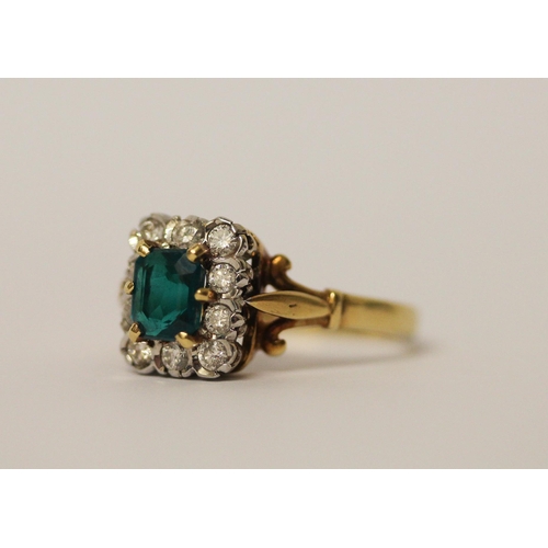 744 - An 18ct gold cluster ring, with emerald cut  green stone to the centre surrounded by diamonds, hallm... 