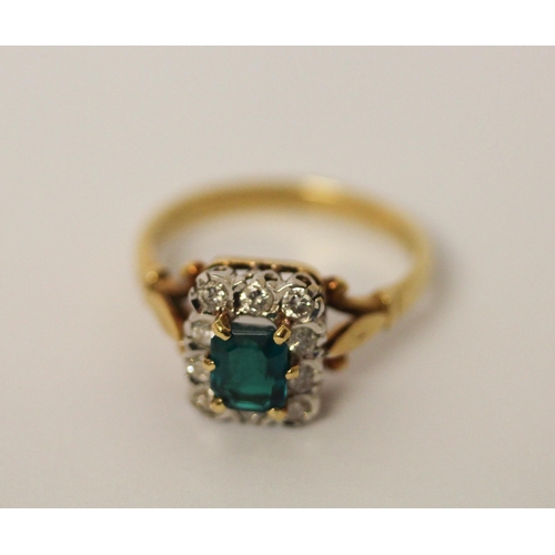 744 - An 18ct gold cluster ring, with emerald cut  green stone to the centre surrounded by diamonds, hallm... 