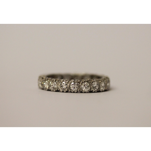 764 - A diamond eternity ring set with 18 brilliant cut diamonds, plain section to back of band, in platin... 