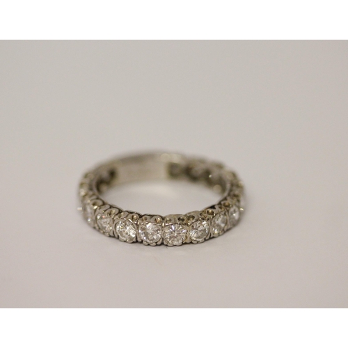 764 - A diamond eternity ring set with 18 brilliant cut diamonds, plain section to back of band, in platin... 