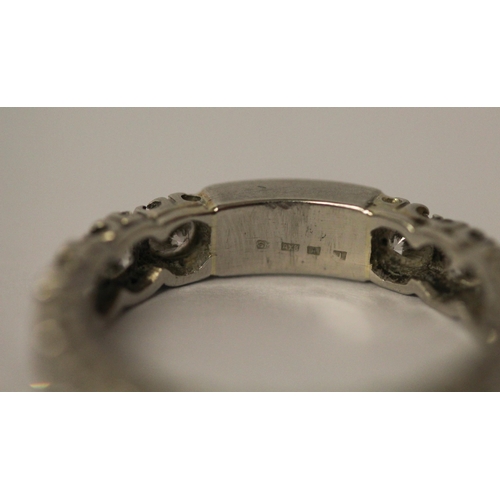 764 - A diamond eternity ring set with 18 brilliant cut diamonds, plain section to back of band, in platin... 