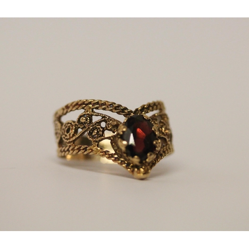 767 - A 9ct yellow gold garnet dress ring in a wishbone design. Ring size O, weight 3 grams