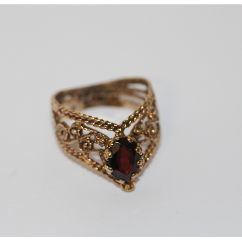 767 - A 9ct yellow gold garnet dress ring in a wishbone design. Ring size O, weight 3 grams