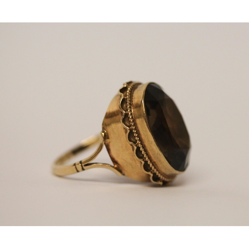 768 - A large smoky quartz oval dress ring, in 9ct gold setting and band. Ring size M