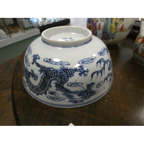 193 - Chinese blue and white circular bowl decorated with a dragon chasing a pearl, four character mark on... 