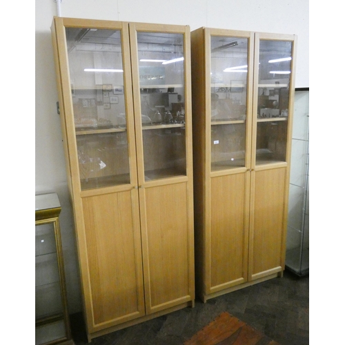 222 - A pair of light oak glazed bookcases standing approximately 6'6 tall with cupboard style bases