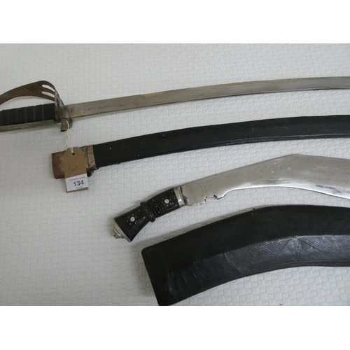 134 - A Kukri in scabbard and a curved sword in scabbard