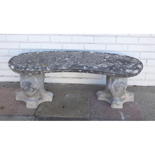 373 - A reconstituted stone curved garden bench with lion head front and back of base