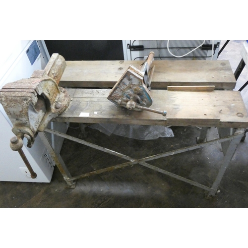 404 - A metal based wooden topped work bench with large engineers vice and one other vice