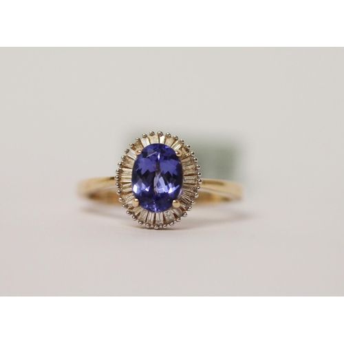 501 - A modern tanzanite and diamond oval cluster ring, the central tanzanite weighing 1.3 carats. Ring si... 