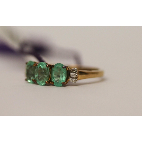 506 - A modern three stone emerald and diamond ring, as new with tags and box, ring size K