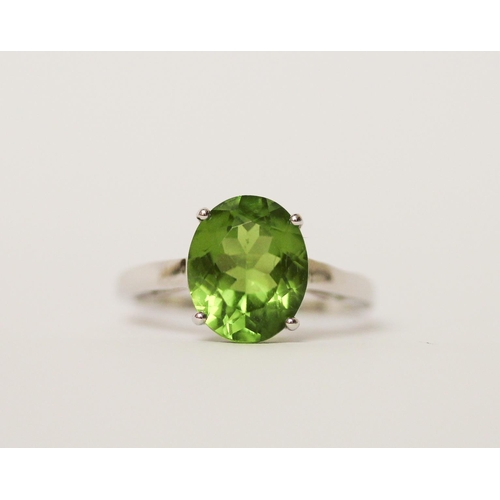 516 - A peridot single stone dress ring on 9ct white gold band. With certificate. Ring size N