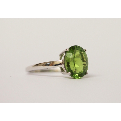 516 - A peridot single stone dress ring on 9ct white gold band. With certificate. Ring size N