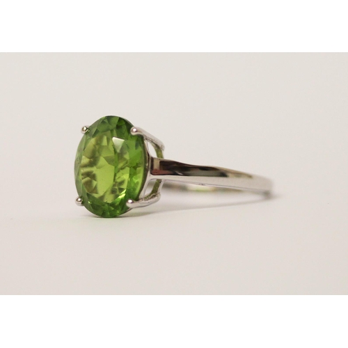 516 - A peridot single stone dress ring on 9ct white gold band. With certificate. Ring size N