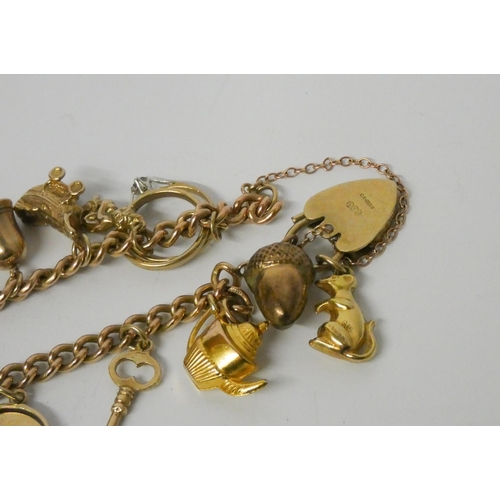 409 - A 9ct gold charm bracelet, set with numerous charms to a heart shaped padlock fastening. Gross weigh... 