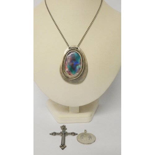 443 - A large silver framed pendant with arts and crafts panel, large opal cross pendant and a St Christop... 