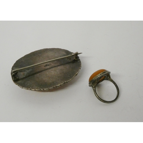 453 - A butterscotch amber oval brooch in 935 standard continental silver frame and a Scandinavian amber p... 