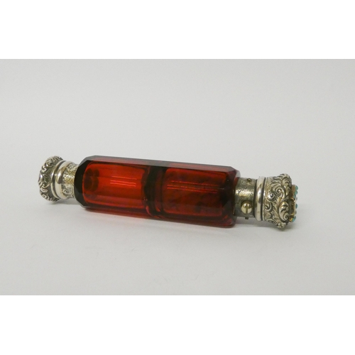 476 - A Victorian ruby glass double ended scent bottle with gilded white metal caps, one inset with turquo... 