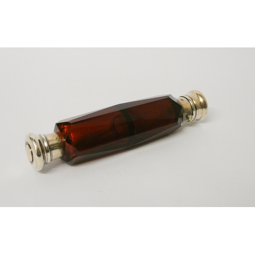 478 - A Victorian double ended faceted ruby glass scent bottle, with screw and hinged lids. 13.5 cms long