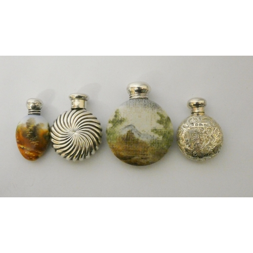 482 - A collection of four scent flasks, two moon shaped hallmarked silver examples and two porcelain and ... 