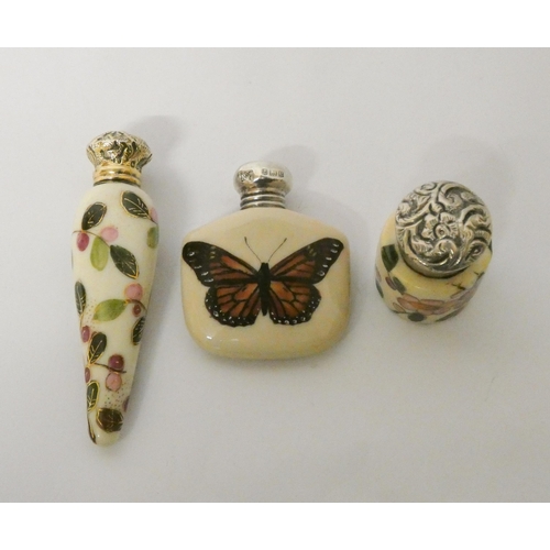 486 - A collection of three silver topped porcelain scent bottles, all with painted decoration. Longest me... 