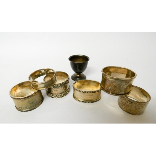 495 - A collection of six silver napkin rings and a silver egg cup, gross weight 6.75 troy oz