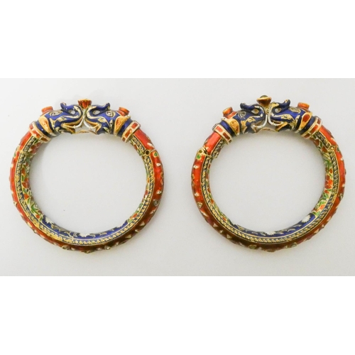 417 - A pair of Indian wedding bangles, decorated with with brightly coloured enamel elephant heads and ro... 