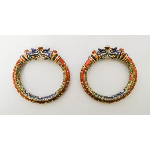 417 - A pair of Indian wedding bangles, decorated with with brightly coloured enamel elephant heads and ro... 