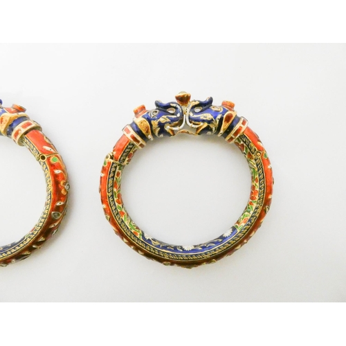 417 - A pair of Indian wedding bangles, decorated with with brightly coloured enamel elephant heads and ro... 