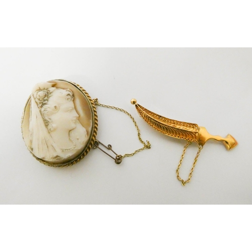 551 - An Arabian gold jambiya dagger brooch, weight 8.8g and a silver gilt framed oval cameo brooch