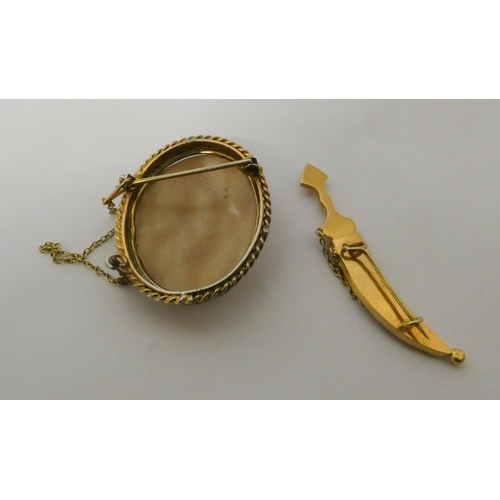 551 - An Arabian gold jambiya dagger brooch, weight 8.8g and a silver gilt framed oval cameo brooch