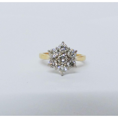 552 - A diamond daisy cluster ring, with seven brilliant cut diamonds on hallmarked 18ct yellow gold band.... 